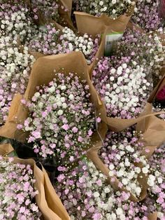 a bunch of flowers that are in some brown paper bags with pink and white flowers on them