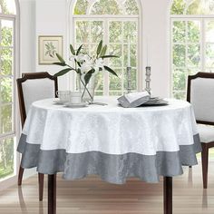 a dining room table with two chairs and a vase filled with flowers