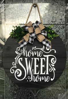 a sign that says home sweet home hanging from a door handle with a bow on it