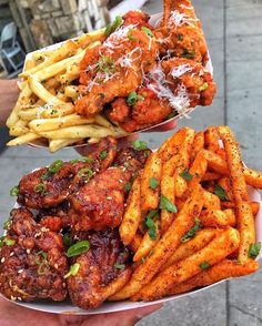 two trays filled with different types of food next to each other on a sidewalk