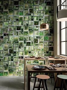 a dining room with a table and chairs in front of a green wallpapered background