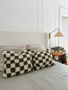 a bed with three pillows on top of it