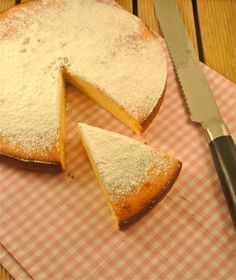 a piece of cake sitting on top of a pink and white checkered cloth next to a knife