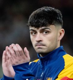 a close up of a soccer player holding his hands together and looking at the camera