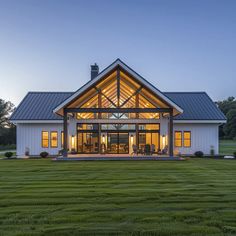 a large white house sitting on top of a lush green field