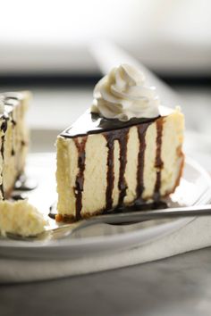 a slice of cheesecake with chocolate sauce and whipped cream