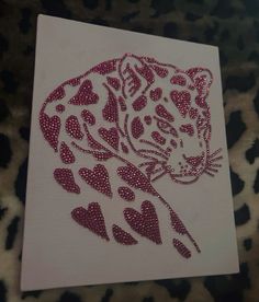 a leopard with hearts on it's face is shown in pink and white fabric