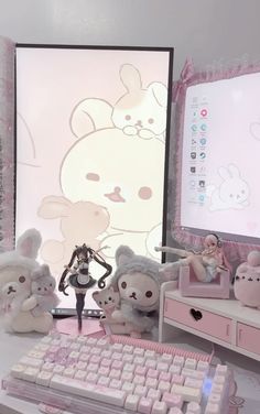 there are many stuffed animals sitting in front of a computer screen and keyboard on the desk