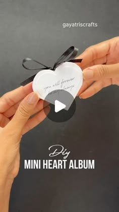 someone is holding a heart shaped card with the words, diy mini heart album