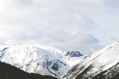 a snowboarder is doing a trick in the air on a snowy mountain slope