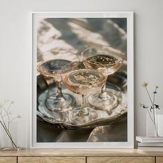 two champagne glasses sitting on top of a silver tray