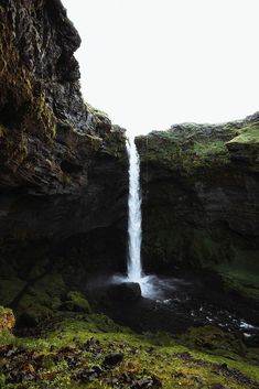 a waterfall in the middle of a rocky cliff