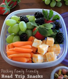 a plastic container filled with assorted fruit and veggies on top of a wooden table