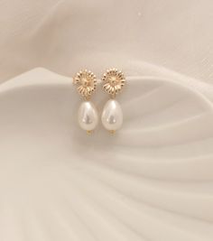 Gold pearly drop earrings - white wedding earrings - bridal earrings - wedding gift - wedding jewelry Pretty pearly pearl earrings made with a white pearly drop, daisy chip clasp in fine gold-plated brass. These pretty earrings measure approximately 2.3 cm in total with the clasp. "All in finesse and delicacy" very light and pleasant to wear they will add a nice touch to your outfit. They will look superb with your wedding outfit, but can also add a glamorous touch to your everyday outfit. Sendi Delicate White Teardrop Flower Earrings, Dainty White Dangle Bridal Earrings, White Pearl Charm Drop Bridal Earrings, White Pearl Charm Drop Earrings For Bridal, White Flower-shaped Earrings With Pearl Charm, Dainty White Pearl Drop Bridal Earrings, White Dangle Bridal Earrings With Pearl Charm, White Teardrop Flower Earrings For Wedding, Dainty White Pearl Earrings