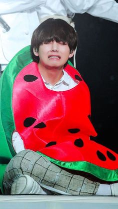 a young boy dressed in a watermelon costume