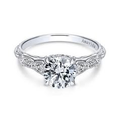 a white gold engagement ring with a round diamond center