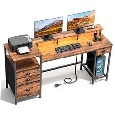 a computer desk with two monitors and a printer on it's side, sitting next to a keyboard