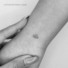 a small lotus tattoo on the wrist