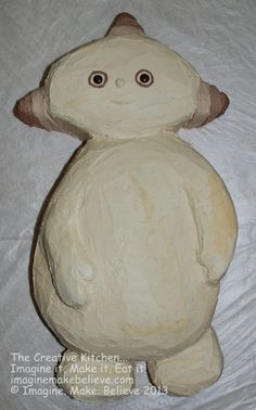 a white stuffed animal sitting on top of a bed