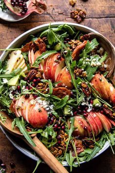 an apple salad with pecans and cranberries in a bowl on a wooden table