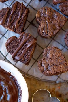 chocolate cupcakes on a cooling rack with a heart - shaped cookie next to them