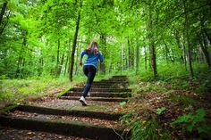 a woman running up some steps in the woods