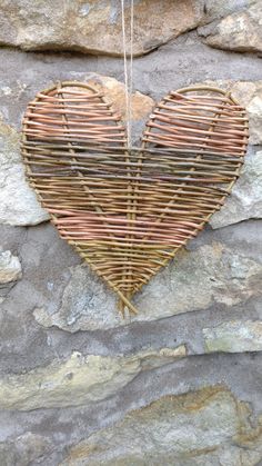 a heart shaped wicker hanging on a stone wall