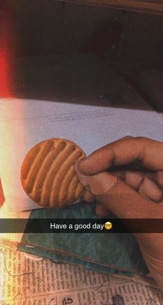 a person holding a piece of bread in their hand with the caption have a good day