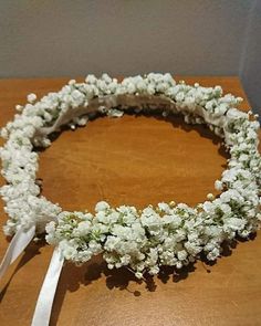 a white flowered headband on top of a wooden table