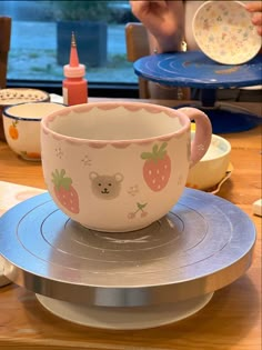 a pink cup sitting on top of a metal plate