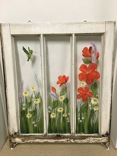 an old window with flowers painted on it