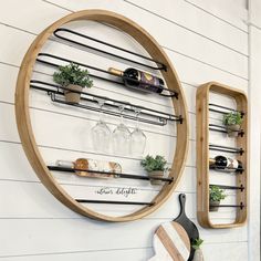 a wall mounted wine rack with bottles and glasses on it next to a cutting board