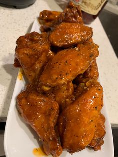 some chicken wings are sitting on a white plate