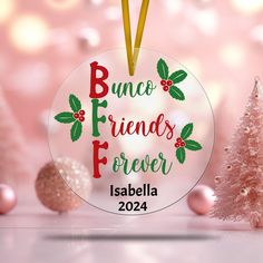 a glass ornament with the words bunco friends forever in front of christmas trees