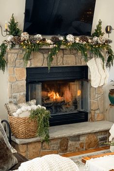 a living room with a fire place and christmas decorations on the mantel above it