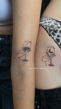 two women with tattoos on their stomachs holding wine glasses and one has a heart