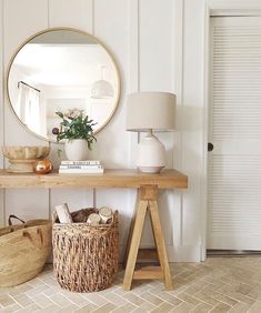 a wooden table topped with a round mirror