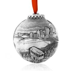 a glass ornament with a train on the tracks in front of a city