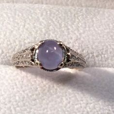 a white gold ring with an amethyst stone