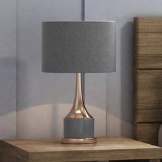 a table with a lamp on it next to a dresser