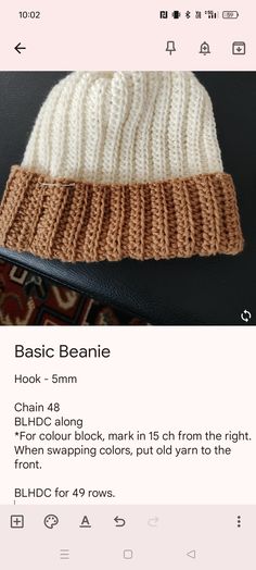 a white and brown knitted beanie sitting on top of a table