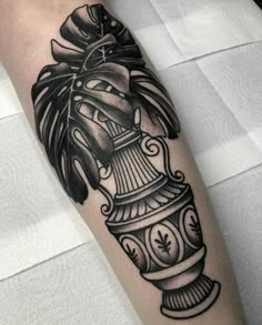 a black and white tattoo on the arm of a person with a clock in it