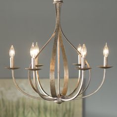 a chandelier with five lights hanging from it's center and four arms