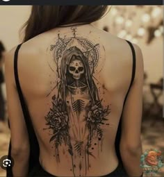 the back of a woman's body with a skeleton and flowers tattoo on it