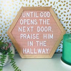 a wooden sign that says until god opens the next door, praise him in the hallway