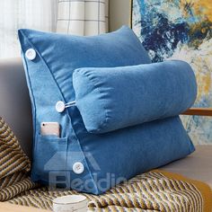 two blue pillows sitting on top of a couch