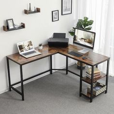 a corner desk with a laptop and monitor on it in an office setting, next to a potted plant