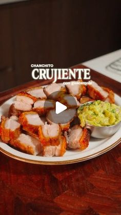 a white plate topped with sliced meat next to a bowl of guacamole