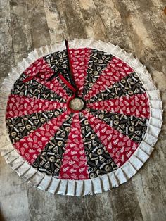 a red and black paper plate sitting on top of a wooden floor