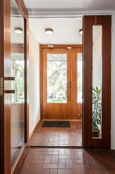 an entry way with two doors and a potted plant